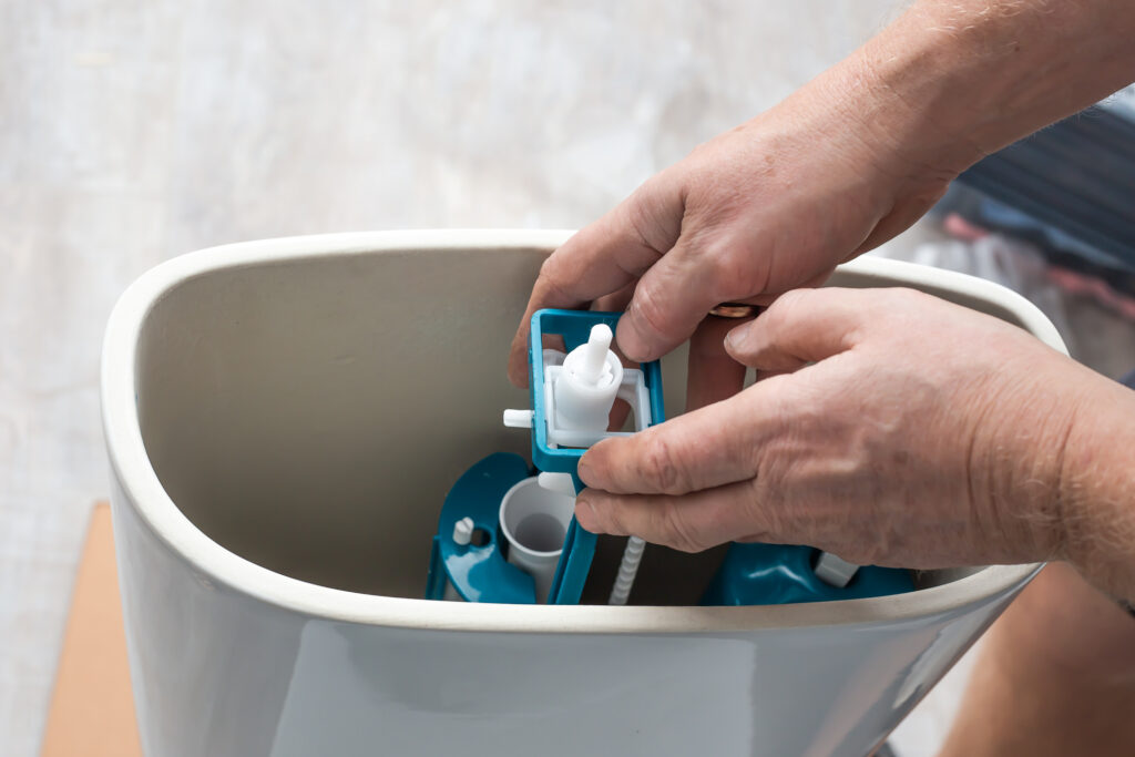 plumber fixing toilet tank internal component