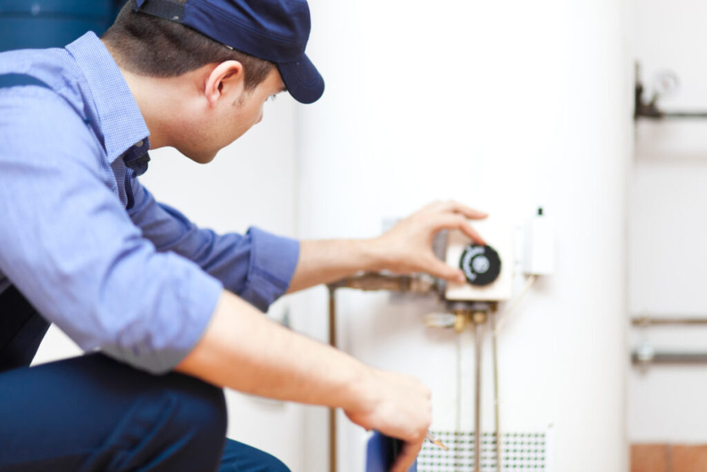 Plumber adjusting the settings on a water heater